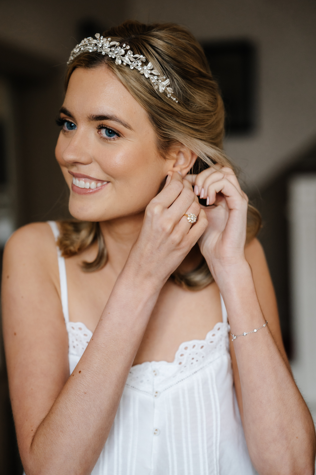 Bride wearing glossy half-up wedding hair with a delicate bridal headpiece