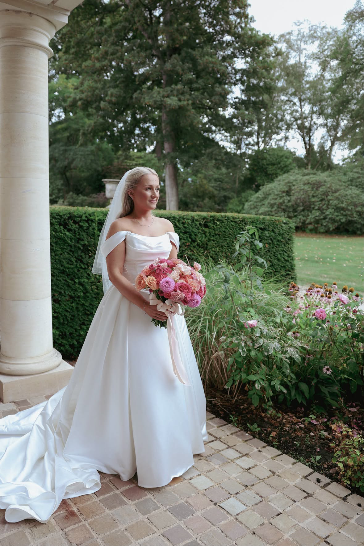 Luan Bridal and Co bride with sleek bridal hair and a short veil in a country-house garden
